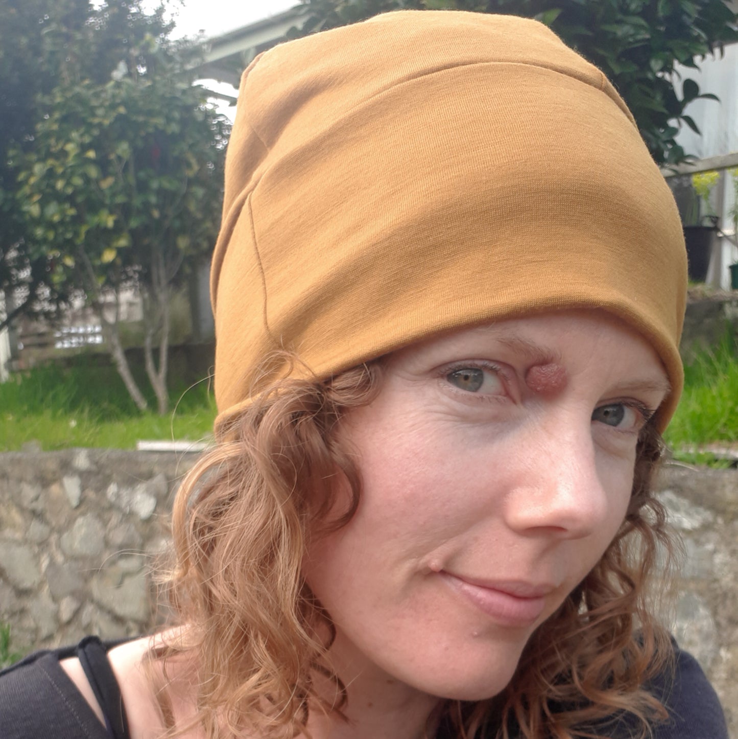 Woman wearing an ochre yellow merino beanie
