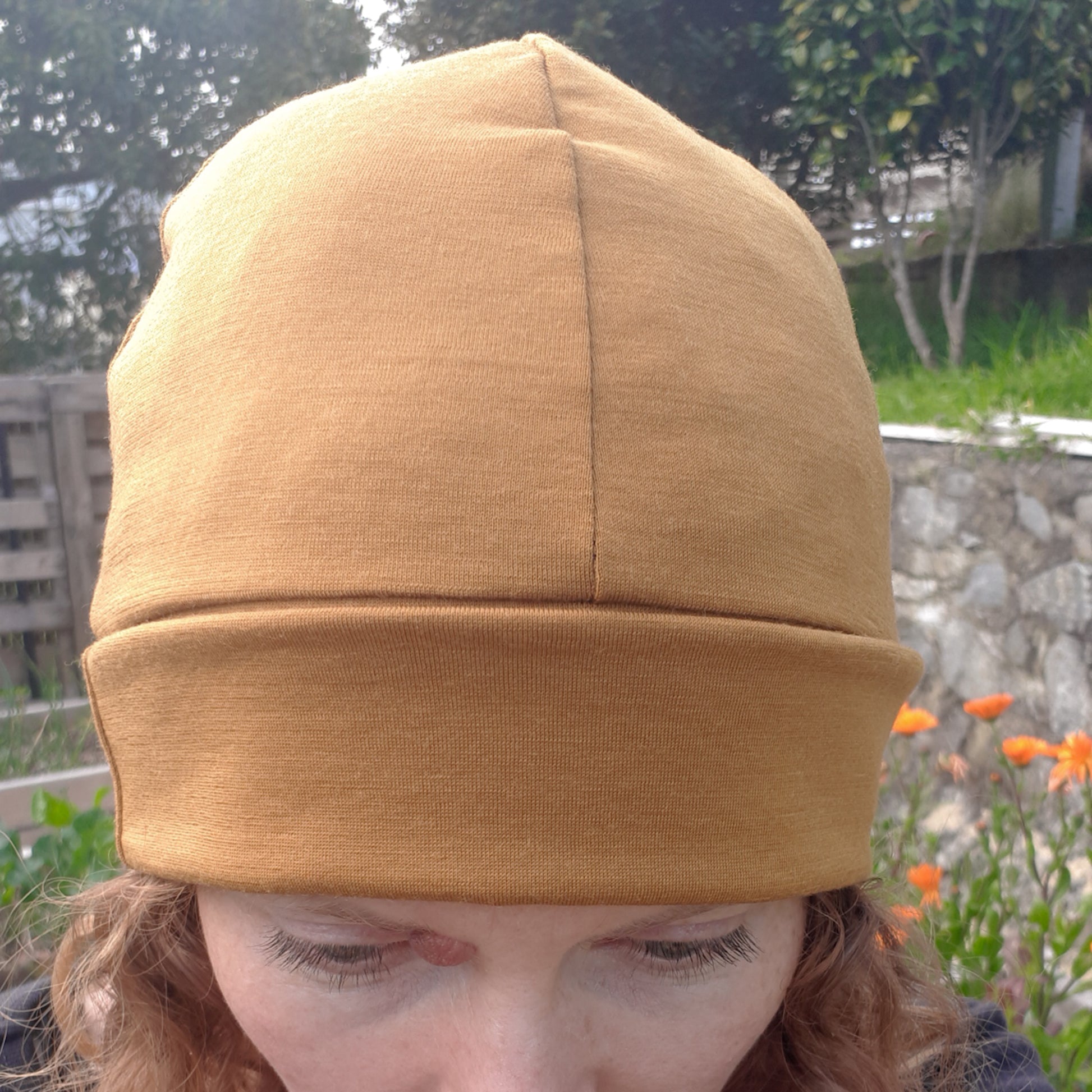 Woman wearing an ochre yellow merino beanie