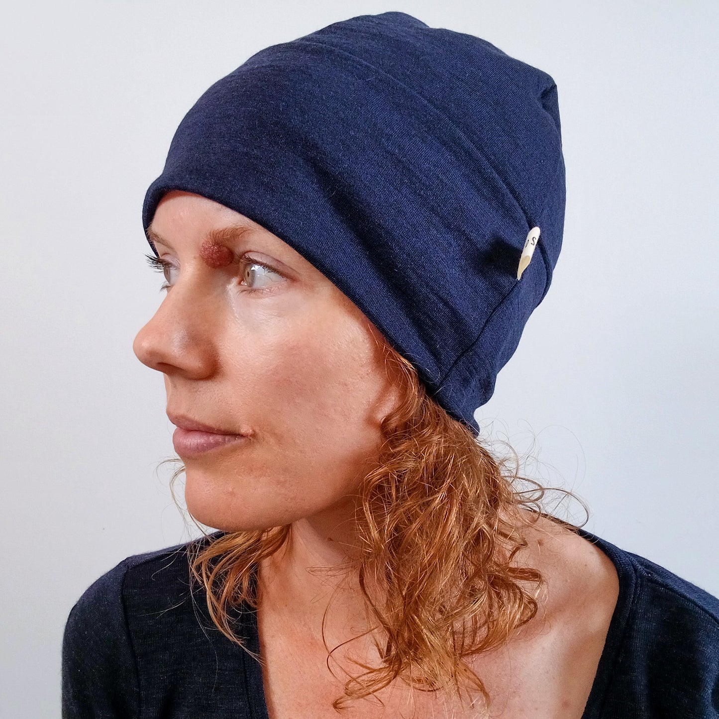 Woman wearing an ink blue merino beanie