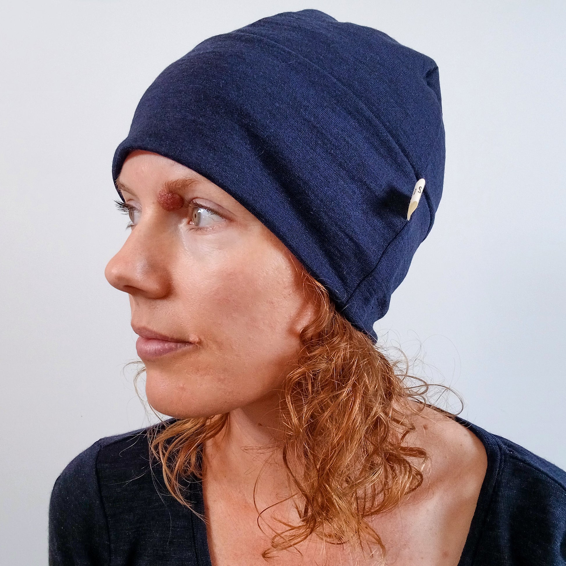 Woman wearing an ink blue merino beanie