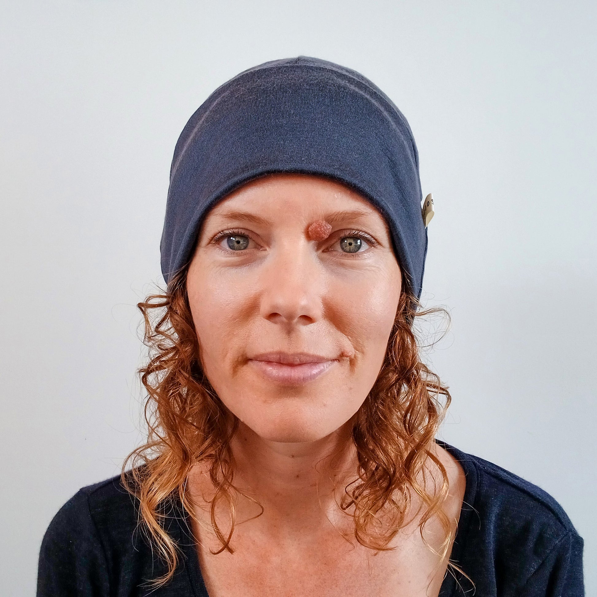 Woman wearing a stone grey merino beanie