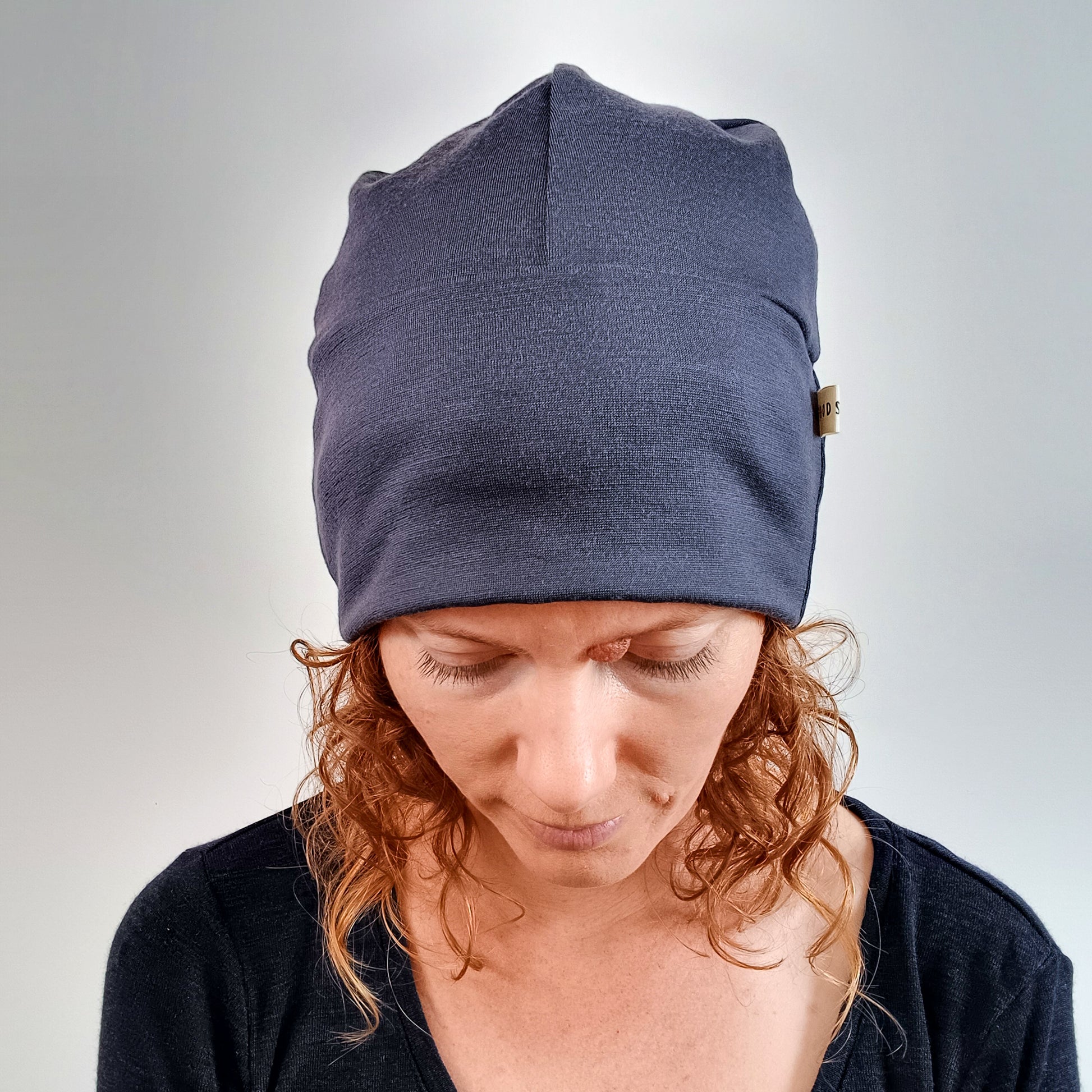 Woman wearing a stone grey merino beanie