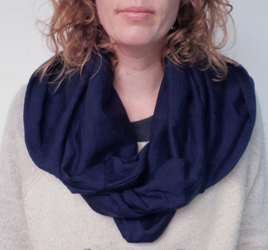 Woman wearing ink blue merino hooded scarf with big hood, hood down